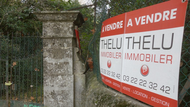 Panneau immobilier « À vendre » installé sur la clôture du domaine