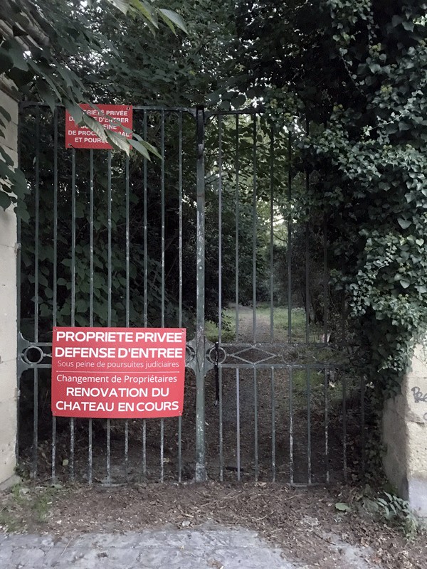 Portail fermé du domaine avec un panneau « Propriété privée, défense d'entrée »