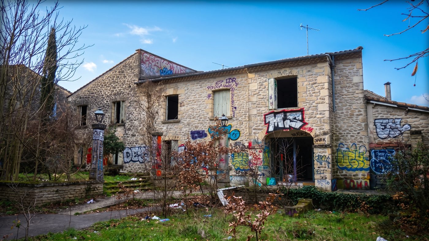 Dépendance en pierre du domaine, avec son entrée voûtée et ses lampadaires d'origine