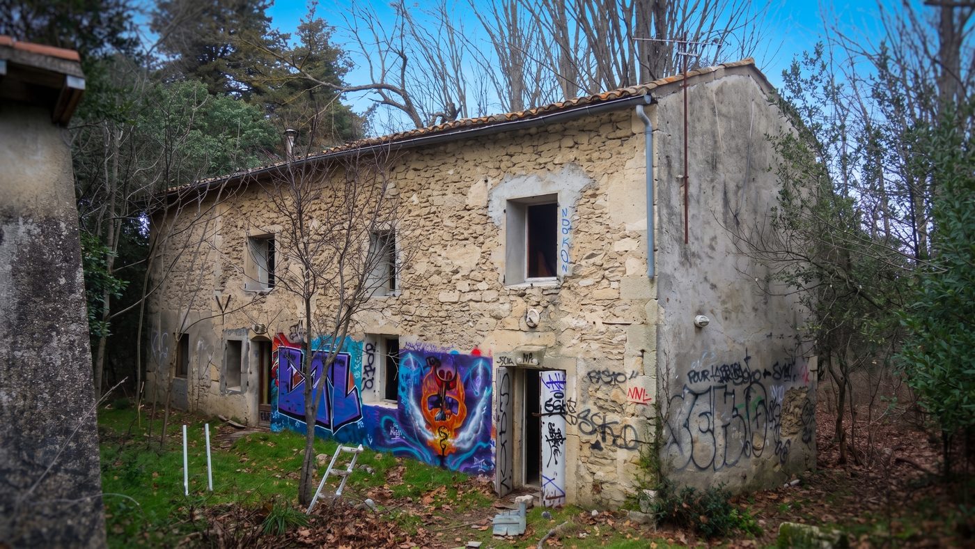 Dépendance en pierre du parc dont la façade est recouverte d'une fresque murale colorée